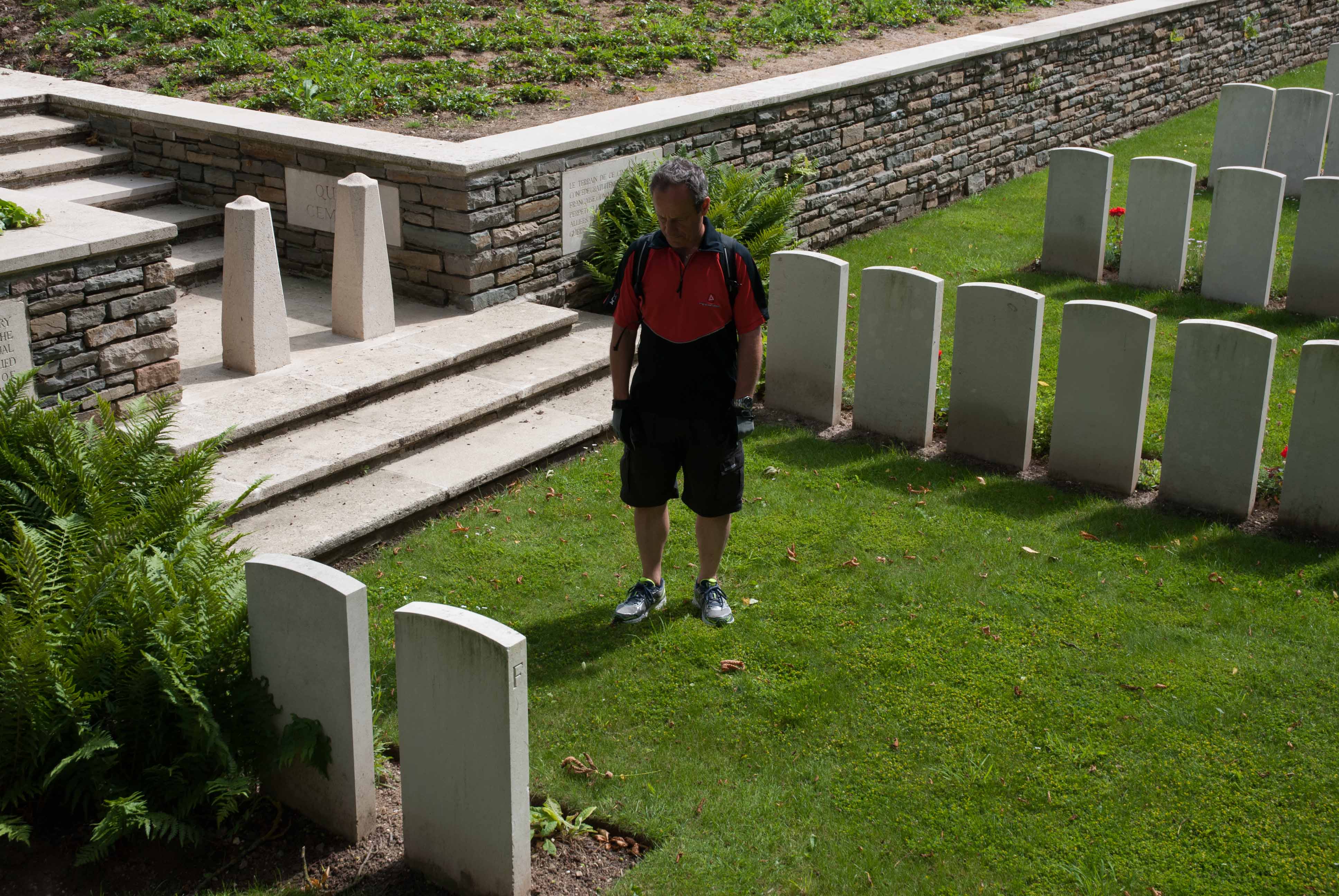Visitor in quiet reflection at a graveside